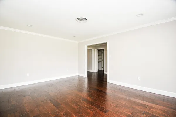 a view of an empty room with wooden floor