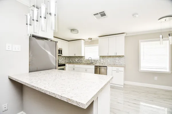 a kitchen with granite countertop a sink a stove and refrigerator