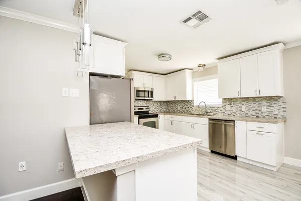 a kitchen with stainless steel appliances granite countertop a sink stove and refrigerator