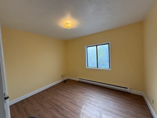 a view of a room with wooden floor and window