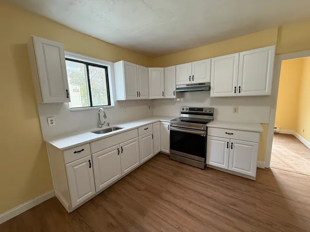 a kitchen with granite countertop white cabinets and white appliances