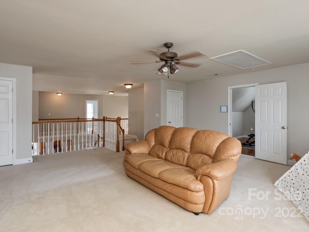 8603 Dansington Court Waxhaw, NC 28173 - Photo 28 of 45 a living room with furniture with a ceiling fan and a rug