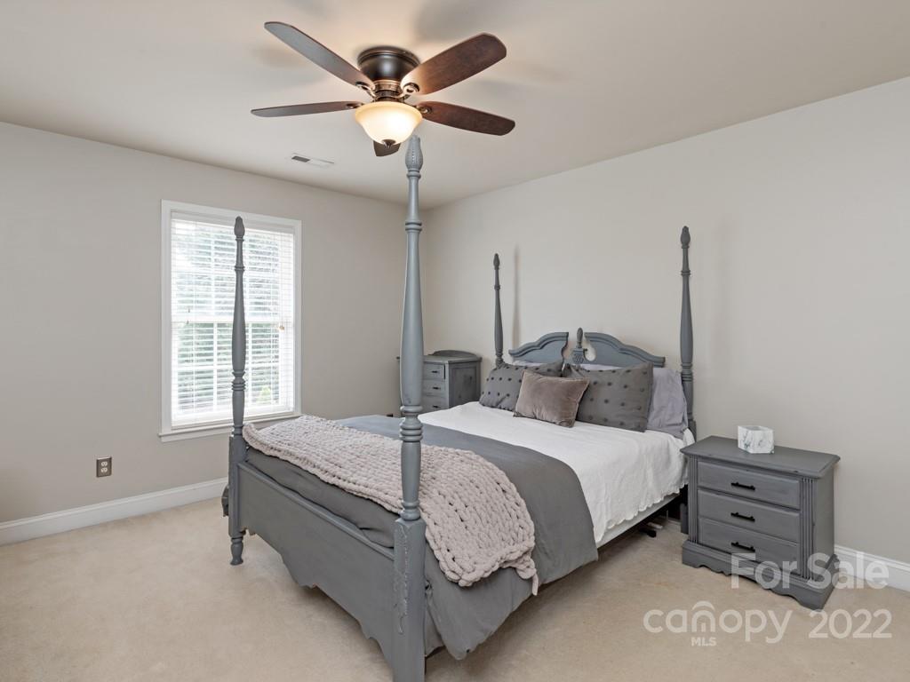 8603 Dansington Court Waxhaw, NC 28173 - Photo 34 of 45 a bedroom with a bed chandelier and a window