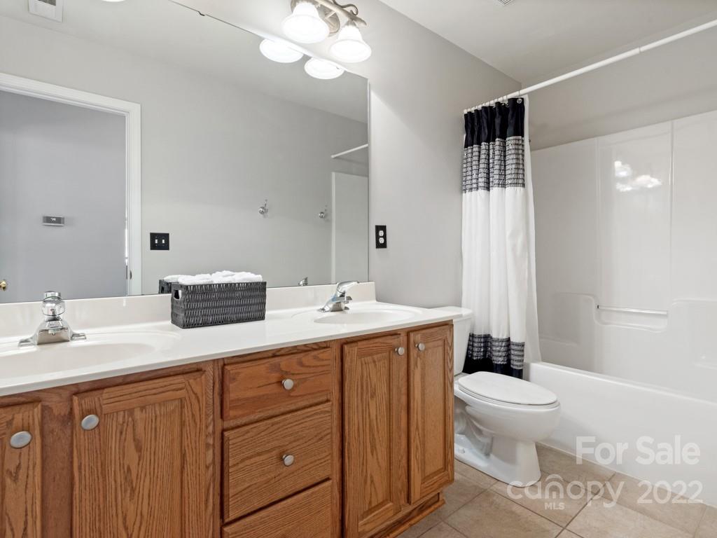 8603 Dansington Court Waxhaw, NC 28173 - Photo 35 of 45 a spacious bathroom with a double vanity sink toilet mirror and shower