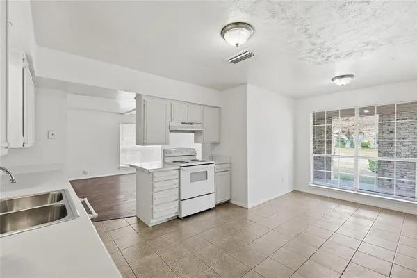 a kitchen with a stove sink and cabinets