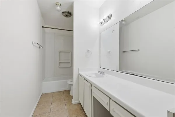 a bathroom with a tub sink vanity and a mirror