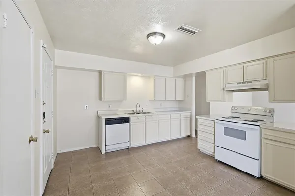 a kitchen with white cabinets and white appliances