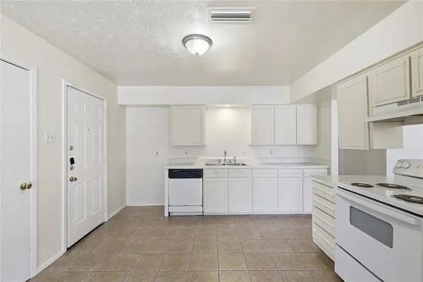 a kitchen with white cabinets and white appliances
