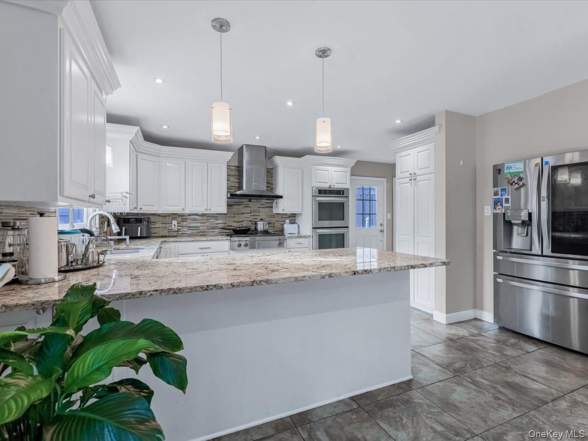 217-32 Corbett Road Queens, NY 11361 - Photo 8 of 25 a kitchen with stainless steel appliances granite countertop a refrigerator a oven a sink a stove and a sink