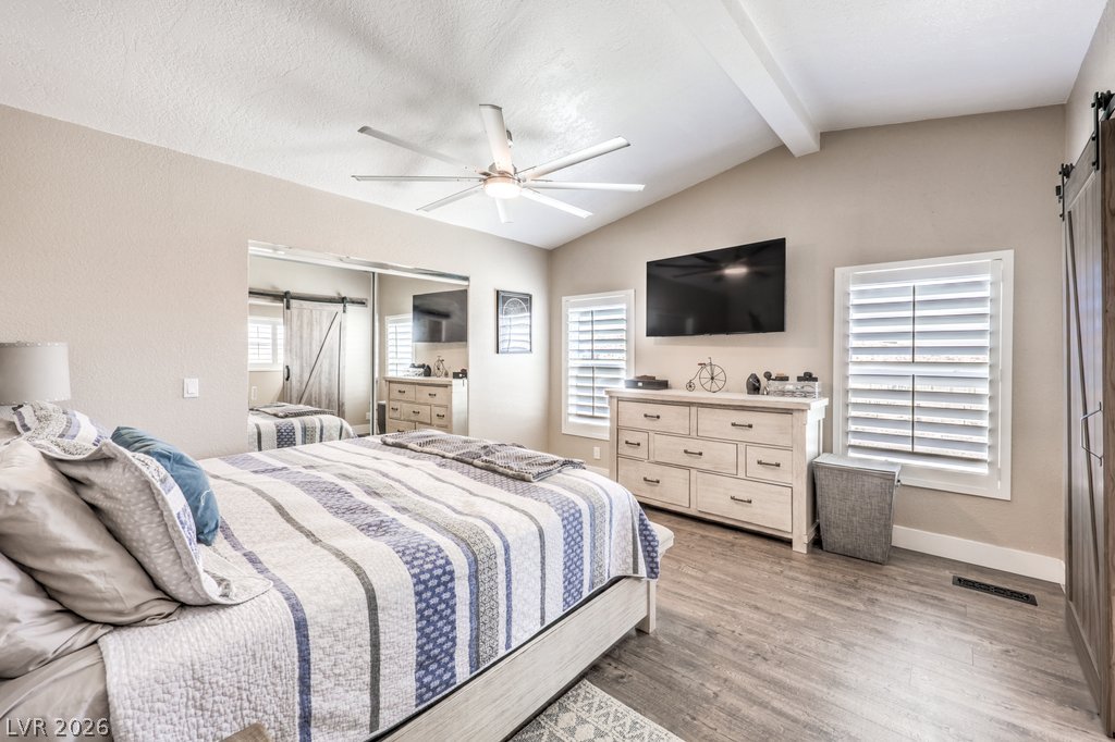 4375 Pinwheel Street Logandale, NV 89021 - Photo 21 of 52 A comfortable bedroom with vaulted ceilings, featuring a large bed and ample natural light from two windows. Shutters throughout the home.