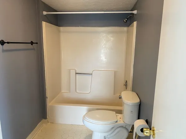 a white toilet sitting next to a bathroom sink and vanity
