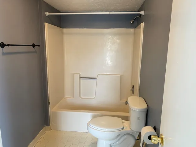 a white toilet sitting next to a bathroom sink and vanity