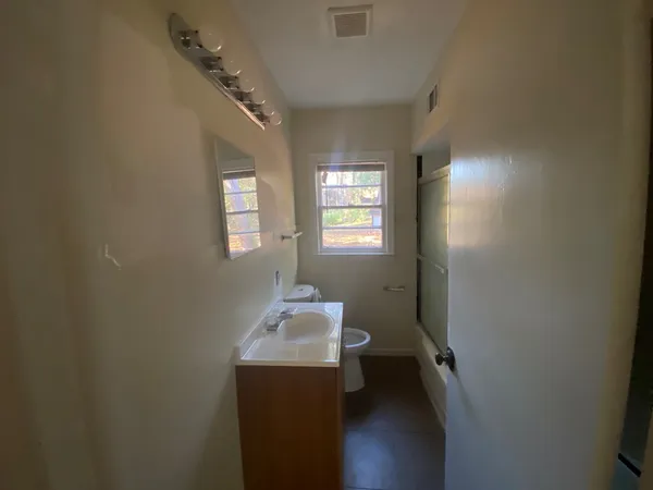 a bathroom with a sink toilet and window