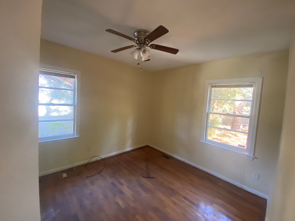 1429 14th Street Columbus, GA 31901 - Photo 10 of 11 a view of an empty room with wooden floor and a window