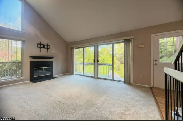 a view of an empty room with a fireplace and a window
