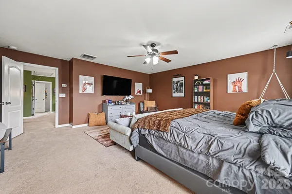 a bedroom with a large bed and flat screen tv