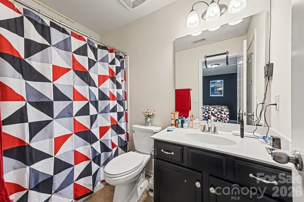 a bathroom with a sink a toilet and shower curtain