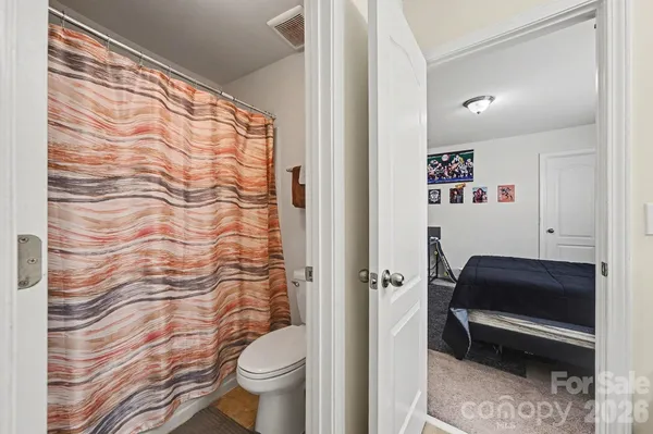 a bathroom with a toilet and a shower curtain
