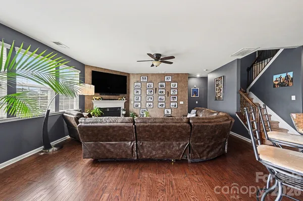 a living room with furniture a flat screen tv and a floor to ceiling window