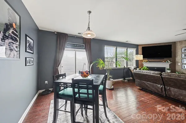 a dining room with wooden floor a chandelier a wooden table and chairs