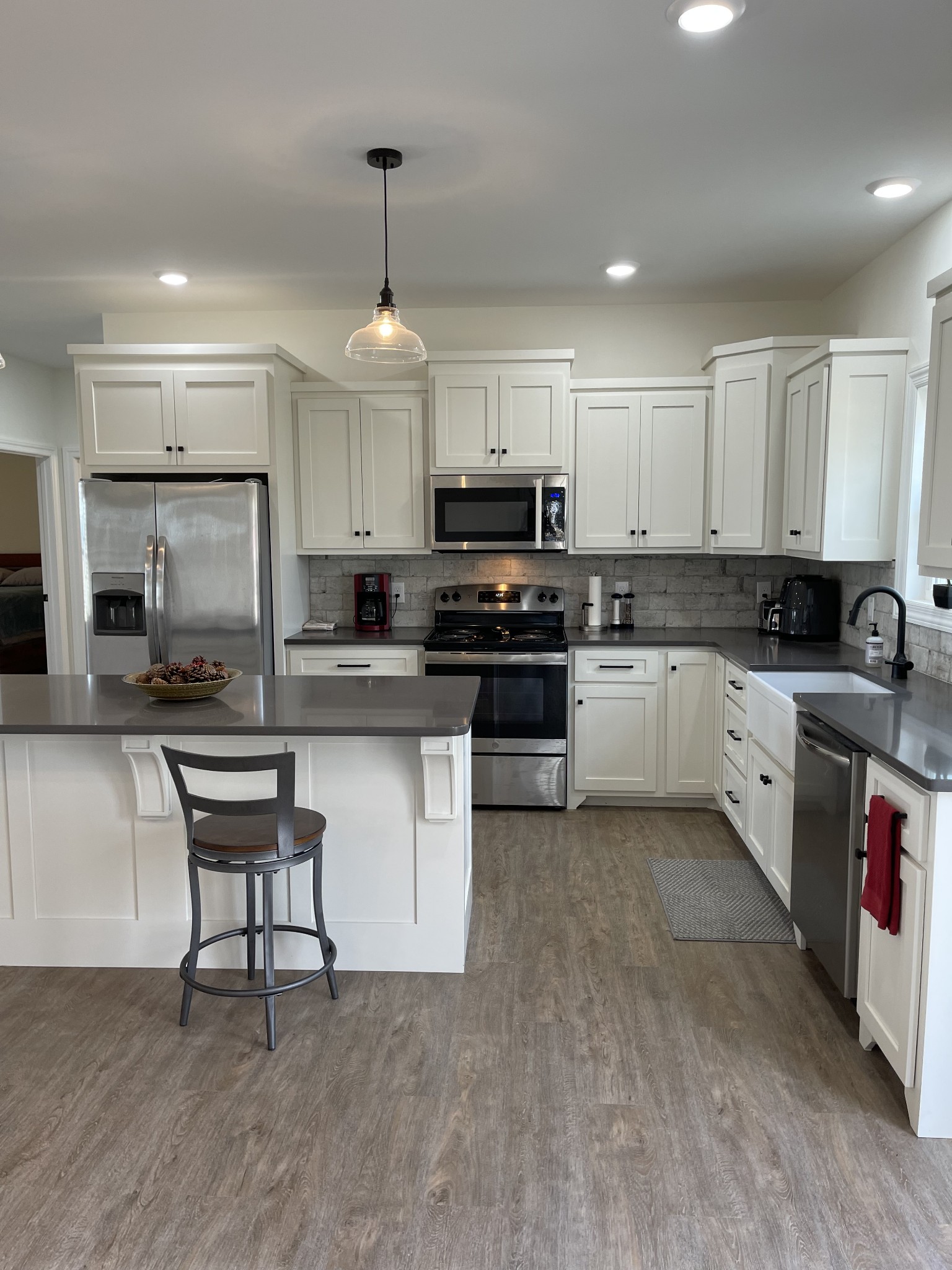 136 Dunn Fall River Road Leoma, TN 38468 - Photo 11 of 25 a kitchen with stainless steel appliances granite countertop a stove a sink a microwave a window and white cabinets