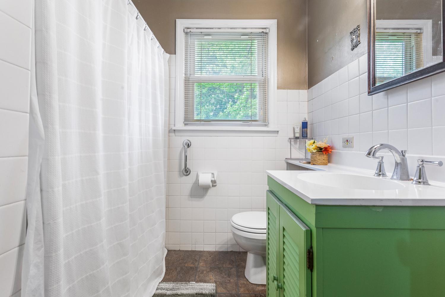 1117 West Union Street Champaign, IL 61821 - Photo 22 of 29 a bathroom with a sink toilet and window