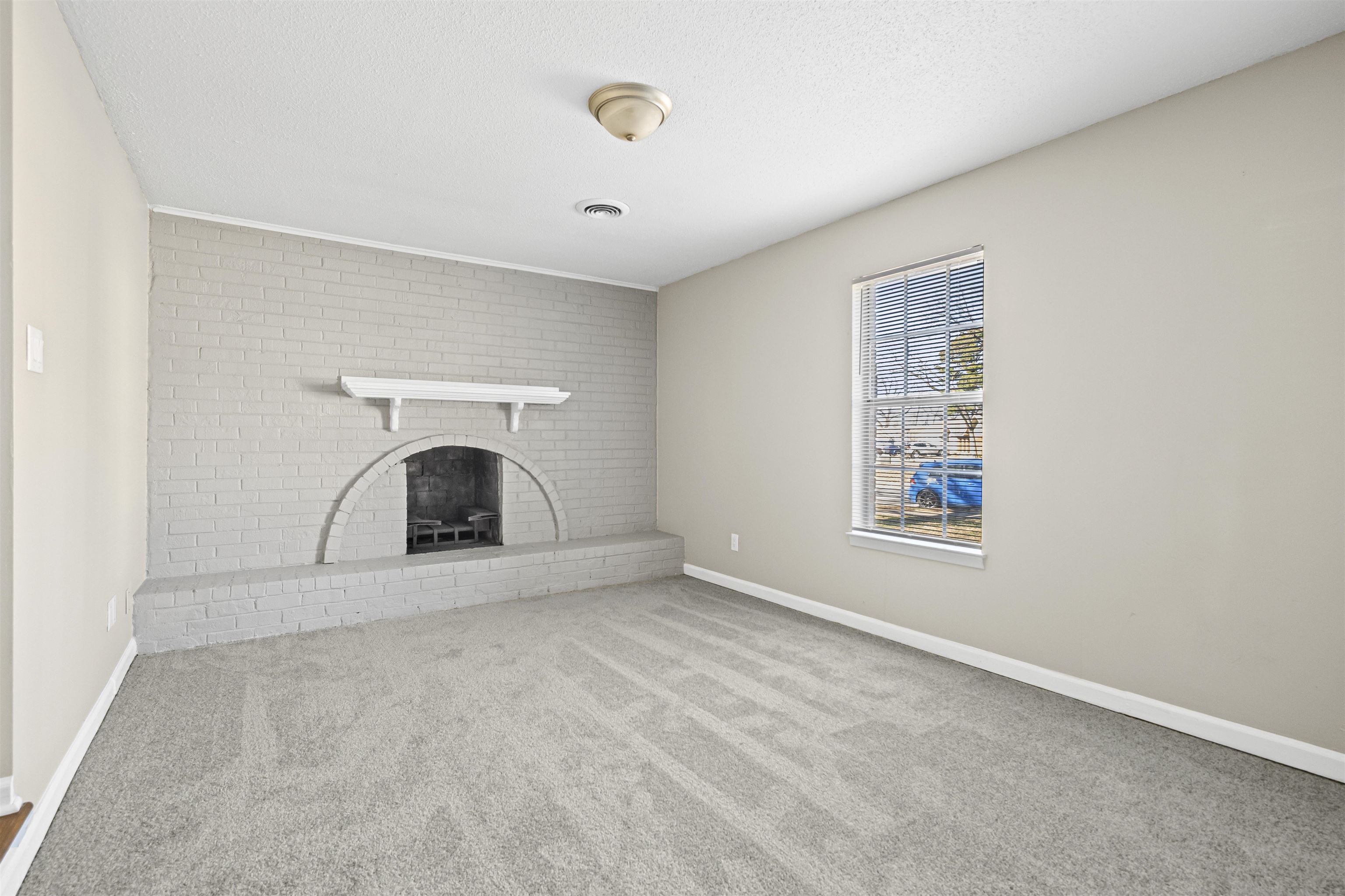 4982 Holly Ridge Drive Memphis, TN 38118 - Photo 4 of 26 an empty room with a fireplace and a window