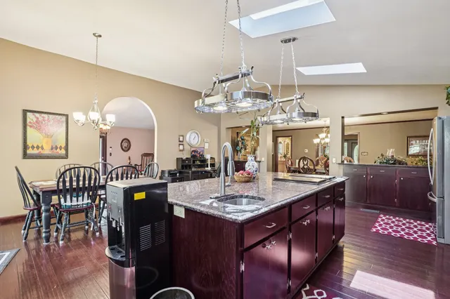 a kitchen that has a lot of white cabinets and wooden floor