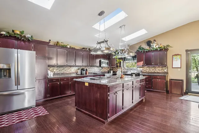 a view of a yard in front of a house with a large tree