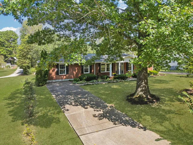 an aerial view of residential house with outdoor space and trees all around