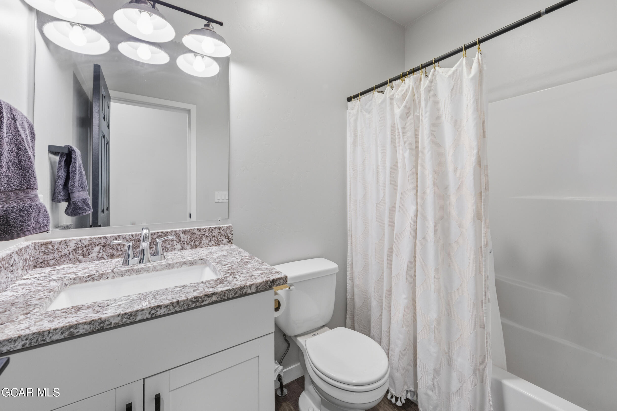 503 12th Street, Unit B Kremmling, CO 80459 - Photo 22 of 44 a bathroom with a granite countertop sink a toilet and a mirror