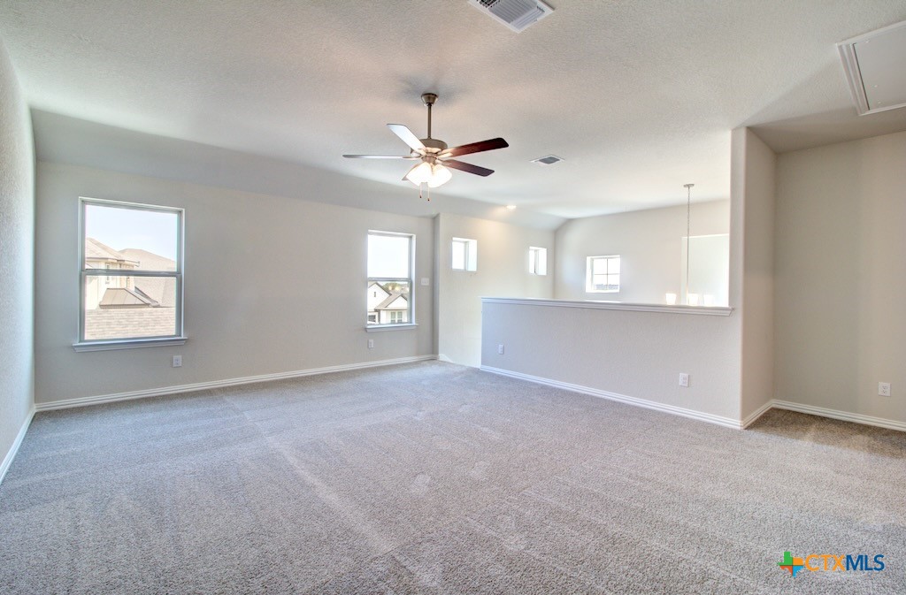 2129 Shepards Street Seguin, TX 78155 - Photo 21 of 29 an empty room with windows and fan chandelier fan