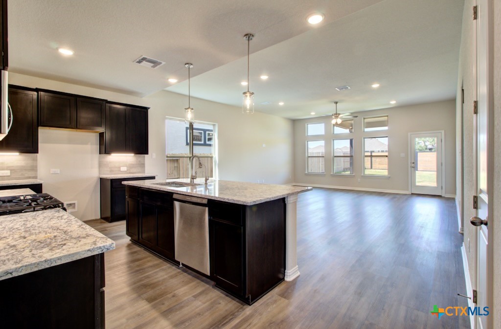 2129 Shepards Street Seguin, TX 78155 - Photo 6 of 29 a kitchen with stainless steel appliances granite countertop a sink a stove and a wooden floors