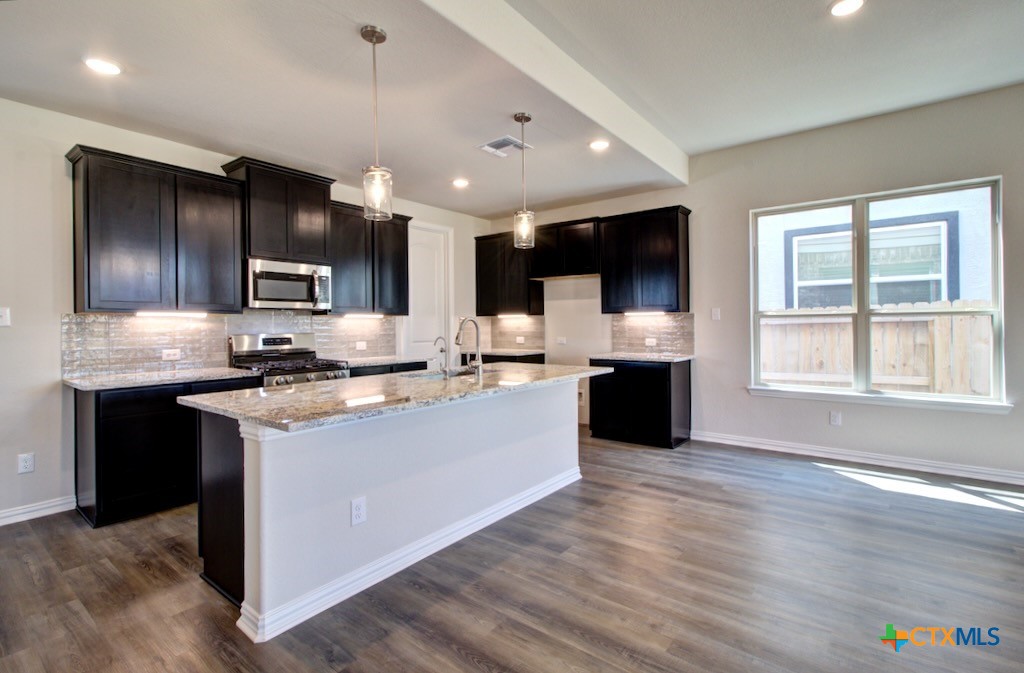 2129 Shepards Street Seguin, TX 78155 - Photo 7 of 29 a large kitchen with stainless steel appliances kitchen island granite countertop a stove and a sink