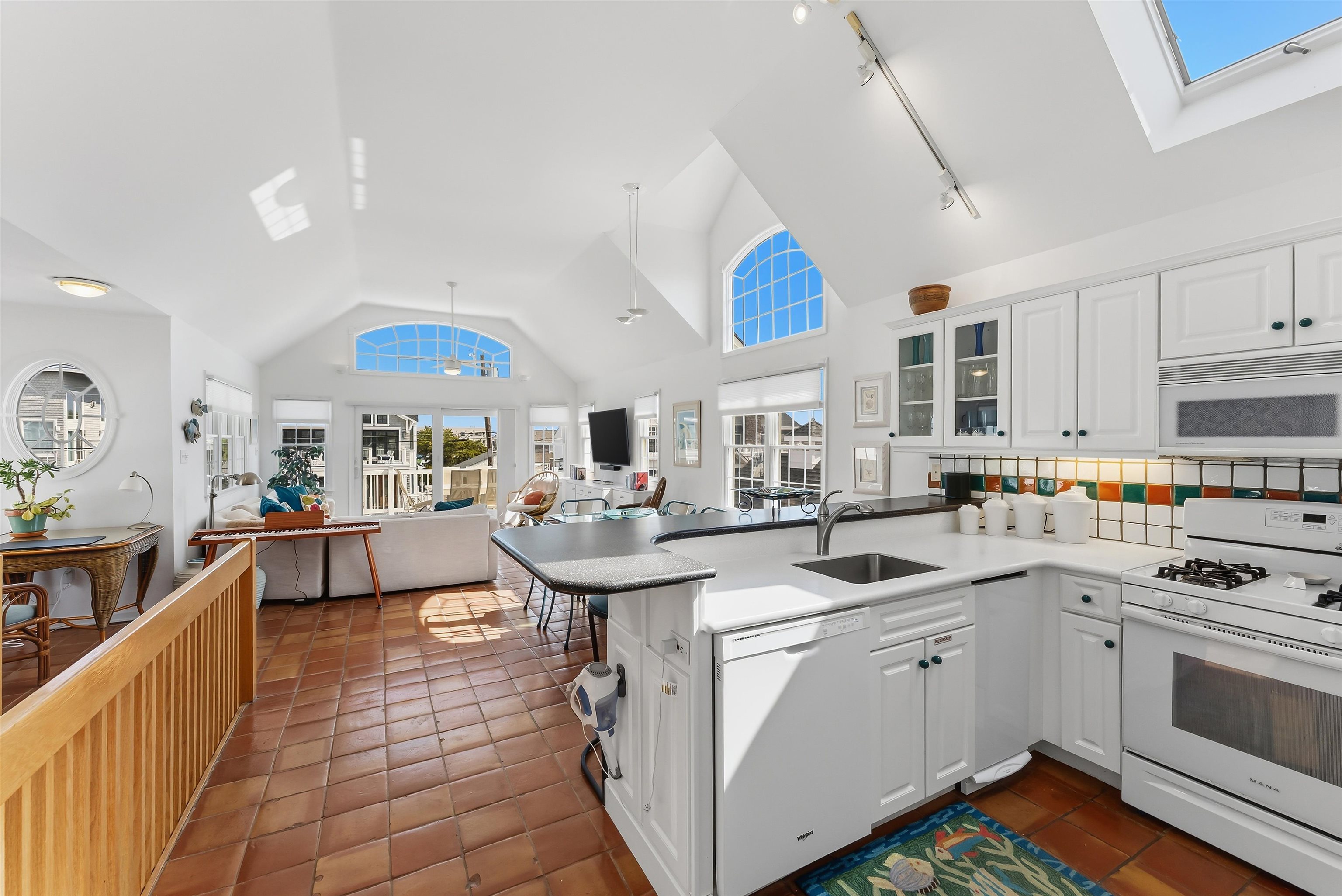 125 98th Street Stone Harbor, NJ 08247 - Photo 11 of 42 a kitchen with stainless steel appliances a sink a stove and cabinets