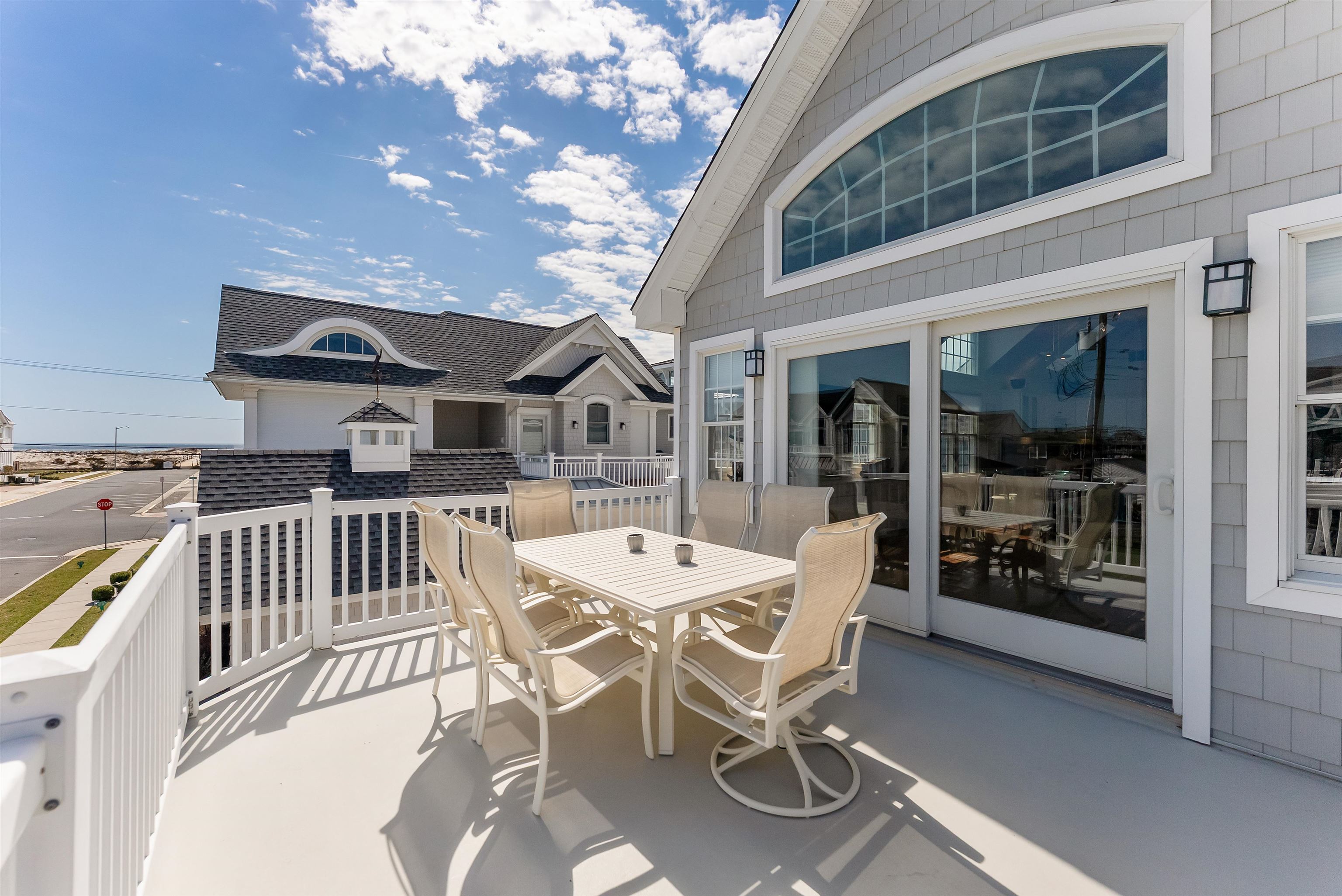 125 98th Street Stone Harbor, NJ 08247 - Photo 13 of 42 a view of a patio with table and chairs with wooden floor and fence
