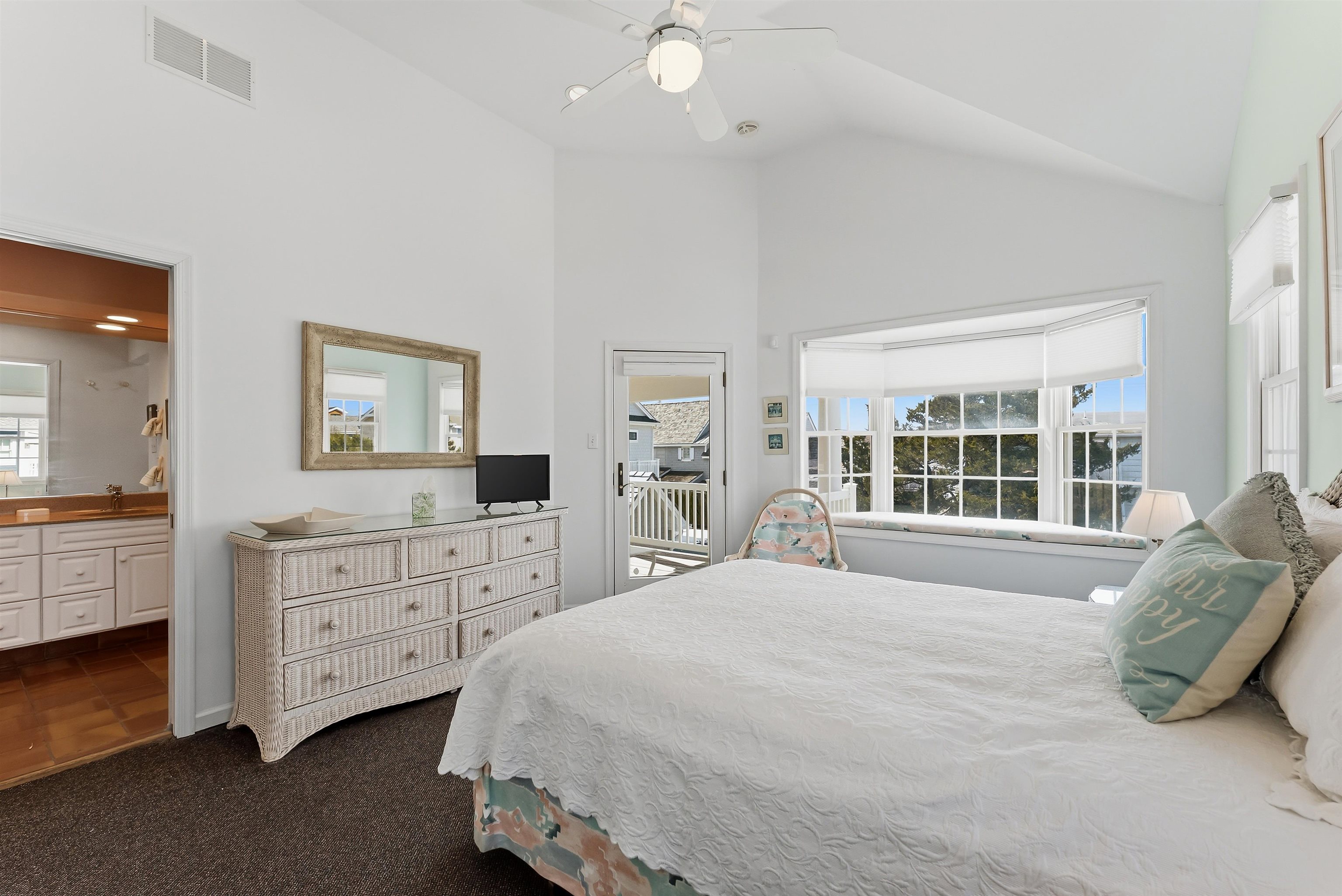 125 98th Street Stone Harbor, NJ 08247 - Photo 18 of 42 a spacious bedroom with a large bed and a flat tv screen on dresser
