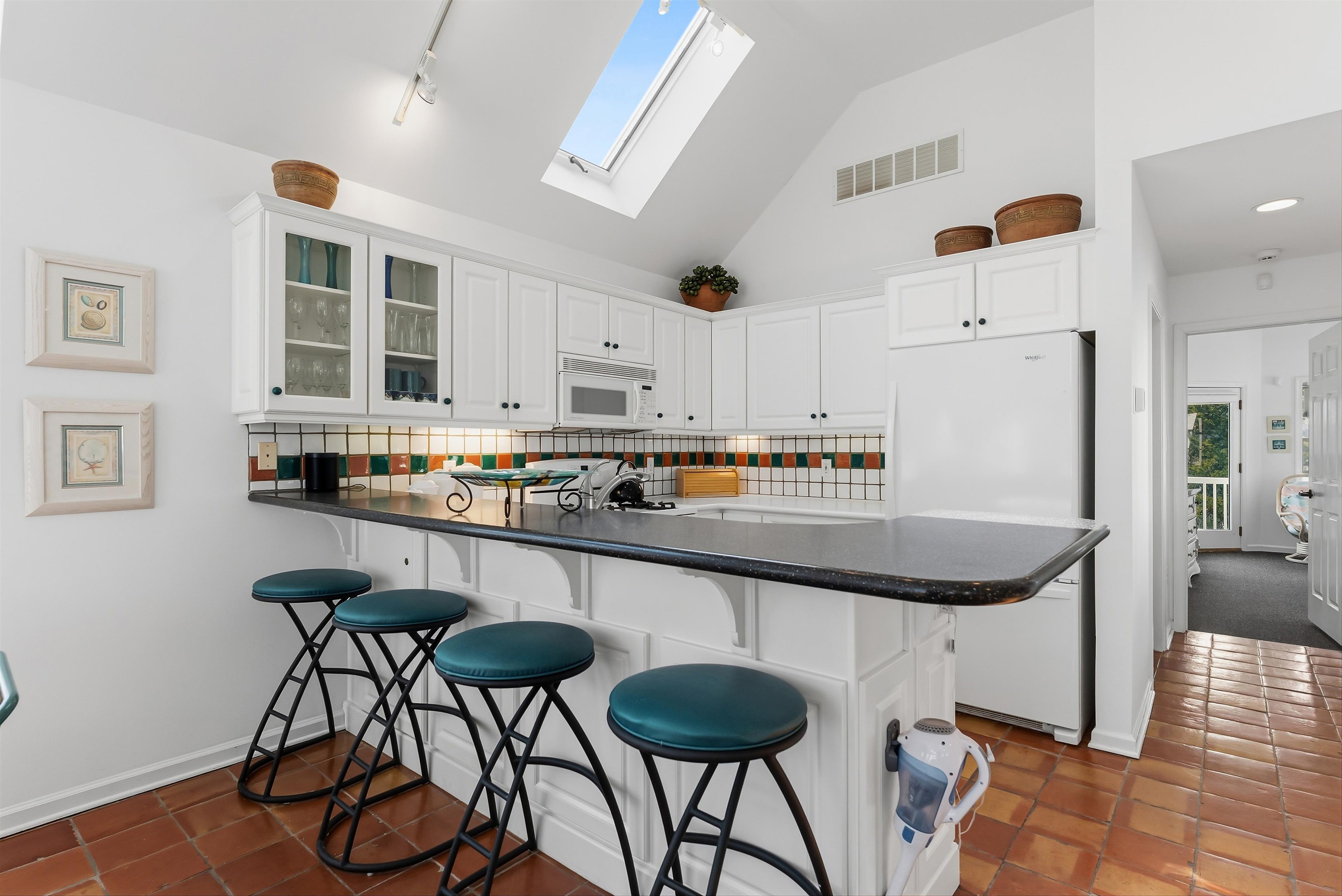 125 98th Street Stone Harbor, NJ 08247 - Photo 10 of 42 a kitchen with stainless steel appliances granite countertop a table chairs in it and white cabinets