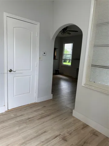 an empty room with wooden floor and mirror