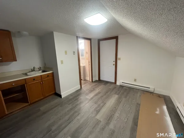 a view of a kitchen with wooden floor and electronic appliances