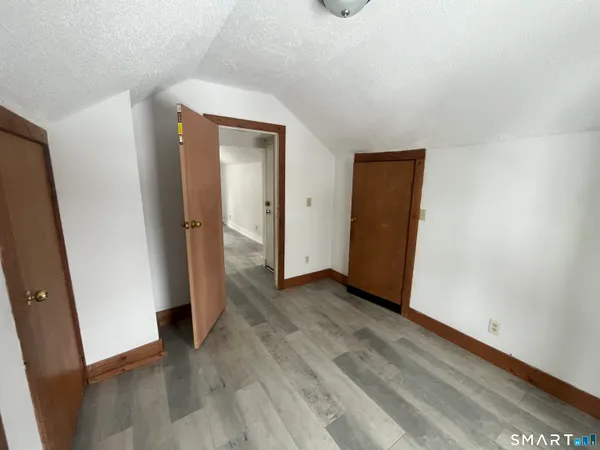 an empty room with wooden floor and entrance