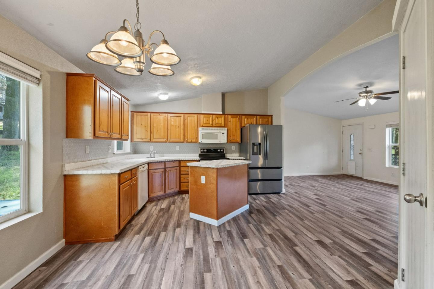 19307 Ferretti Road Groveland, CA 95321 - Photo 10 of 33 a kitchen with stainless steel appliances granite countertop wooden floors a stove and white cabinets