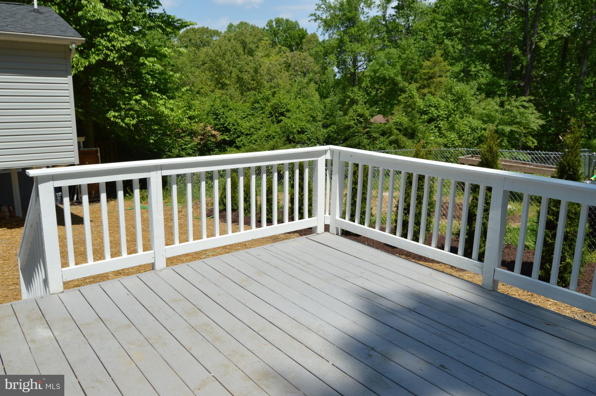 6034 Linden Road St. Leonard, MD 20685 - Photo 20 of 22 a balcony with wooden floor and trees in the back