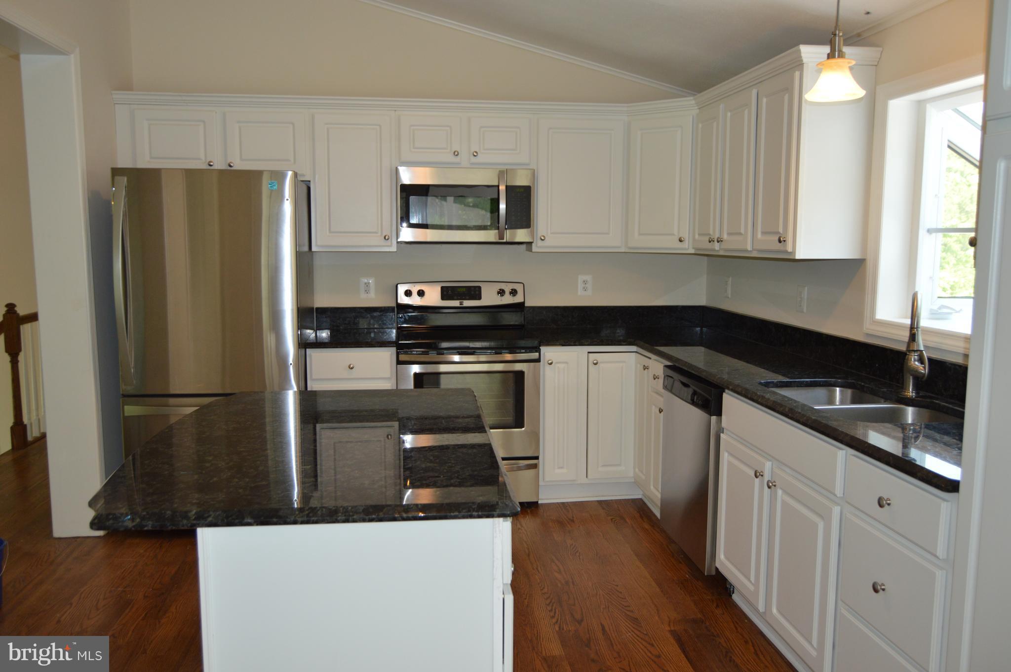 6034 Linden Road St. Leonard, MD 20685 - Photo 3 of 22 a kitchen with stainless steel appliances granite countertop a refrigerator a stove a sink and white cabinets
