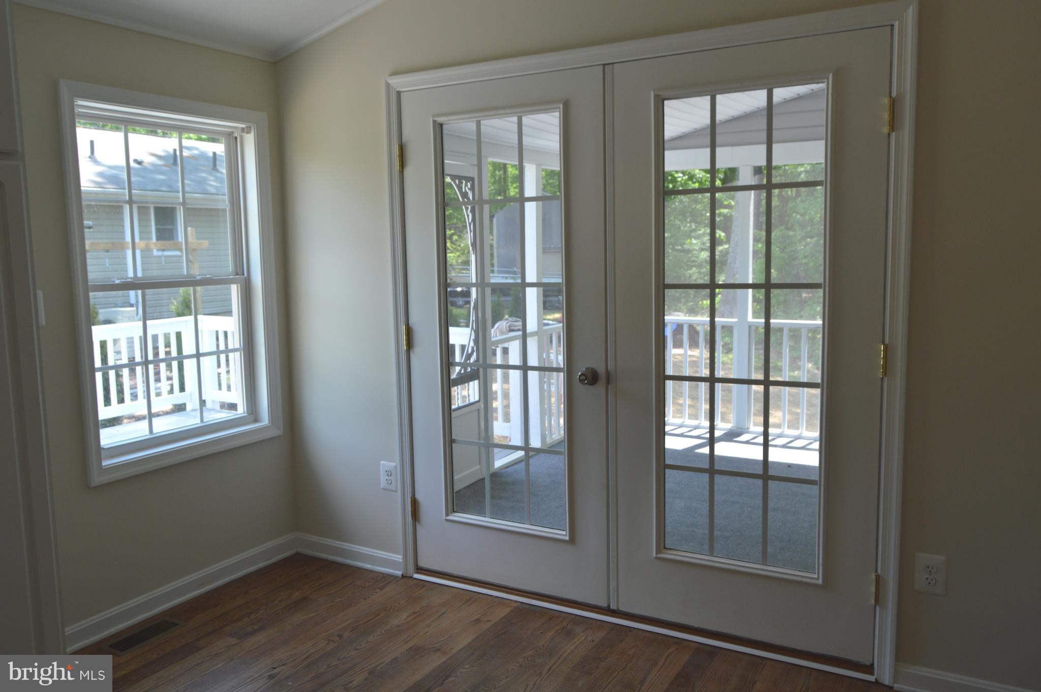 6034 Linden Road St. Leonard, MD 20685 - Photo 4 of 22 an empty room with wooden floor and windows