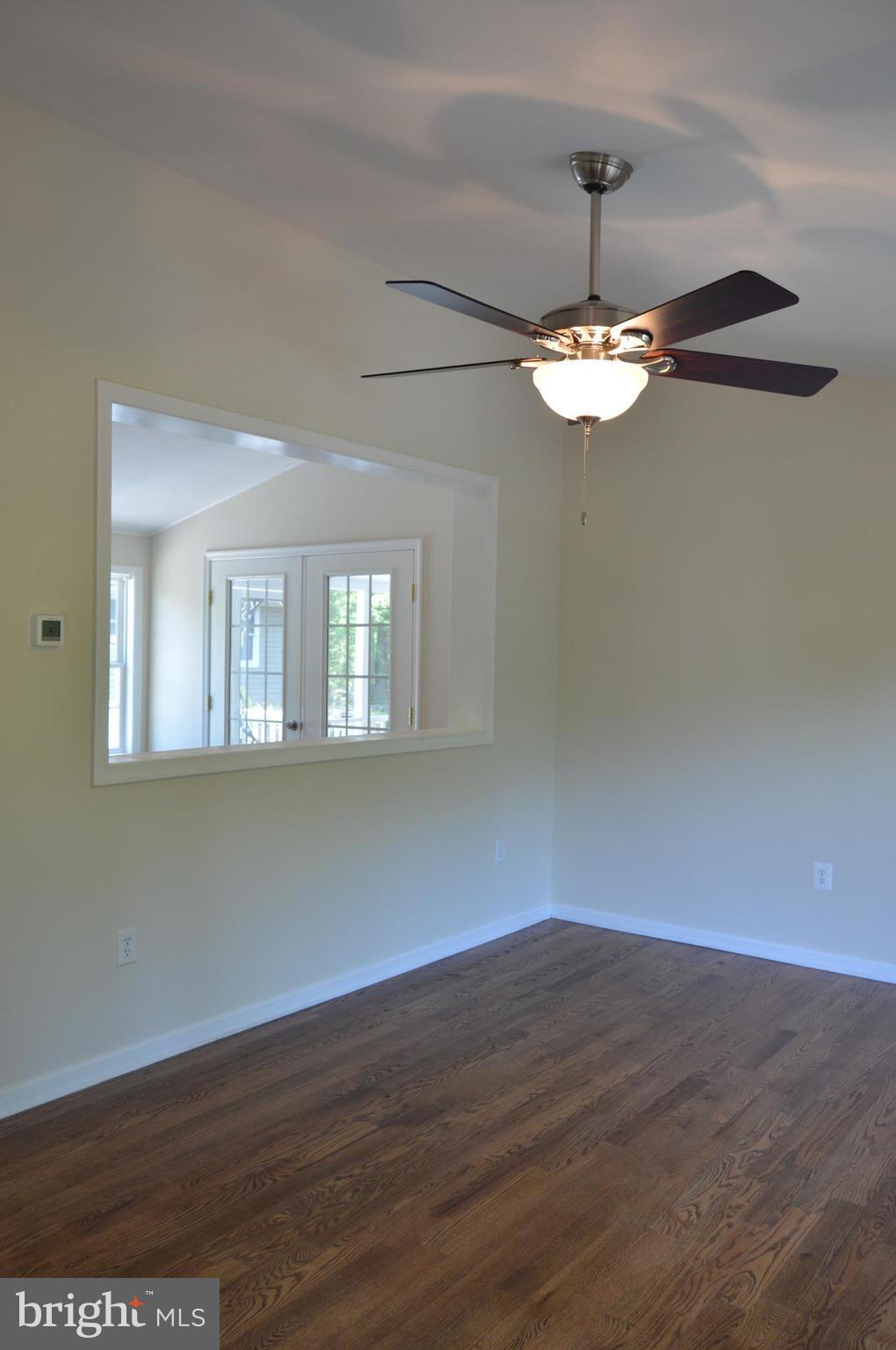 6034 Linden Road St. Leonard, MD 20685 - Photo 6 of 22 a view of empty room with wooden floor and chandelier