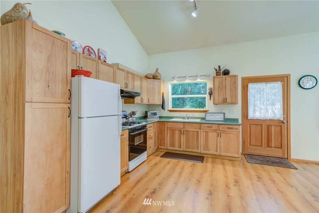 7565 Bear Ridge Way Maple Falls, WA 98266 - Photo 11 of 25 a kitchen with granite countertop a refrigerator and a stove top oven