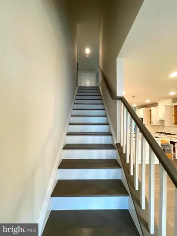 a view of a living room with wooden floor and a kitchen