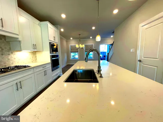 a bathroom with a tub sink vanity granite and shower