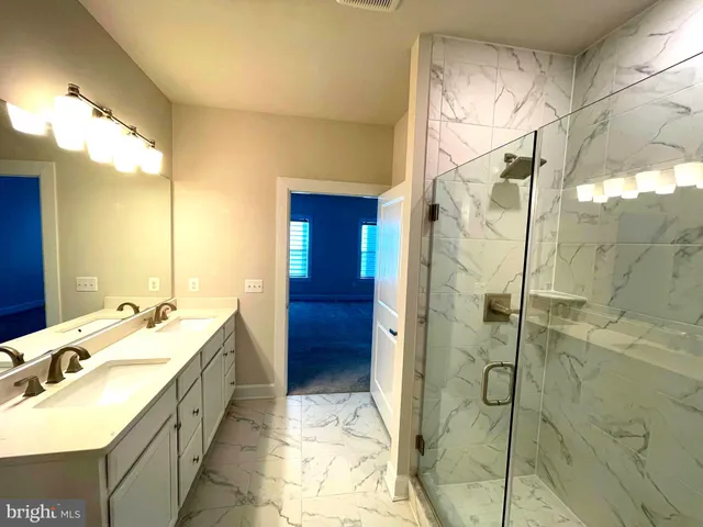 a view of an empty room with wooden floor and windows